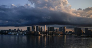 City skyline and harbor are seen at sunrise from a quarantine bus window during the Tokyo 2020 Olympic Games in Tokyo, Japan, July 24, 2021. (Reuters Photo)