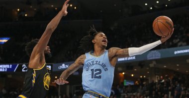 Memphis Grizzles' Ja Morant (R) drives to the basket as Golden State Warriors' Andrew Wiggins (L) defends during an NBA game in Memphis, Tennessee, U.S., Jan 11, 2022. (Reuters Photo)
