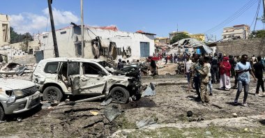 Civilians look at the wrecked vehicles at the scene of an explosion in the Hamarweyne district of Mogadishu, Somalia, Jan. 12, 2022. (Reuters Photo)