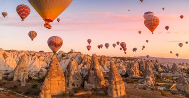 Hot air balloons carrying tourists during a pink sunrise floating along the valleys of Göreme National Park, Turkey, Oct. 7, 2019. (Shutterstock Photo)