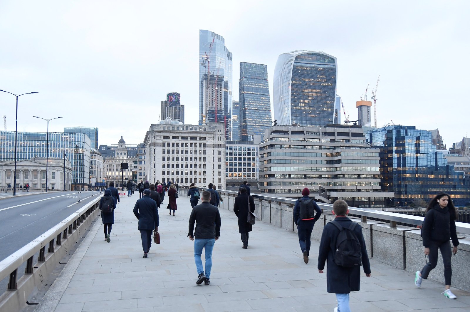 Workers cross London Bridge, with the City of London financial district seen behind, during the morning rush-hour, in London, U.K., Jan. 4, 2022. (Reuters Photo)