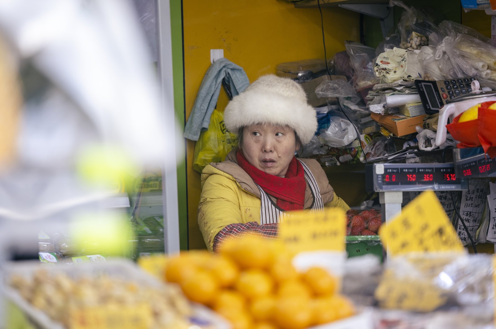 A woman sells fruit in a street shop in Shanghai, China, Jan. 11, 2022. (EPA Photo)