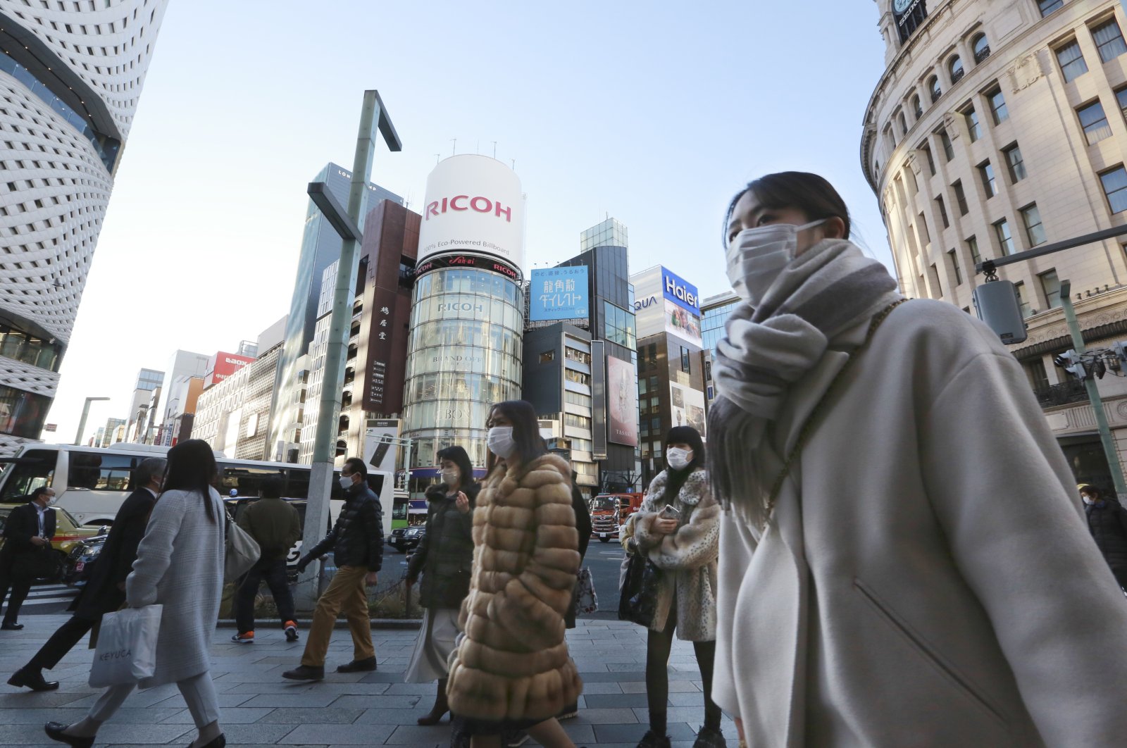 People wearing face masks to contain the spread of the coronavirus walk on the street in Tokyo, Japan, Jan. 12, 2022. (AP Photo)