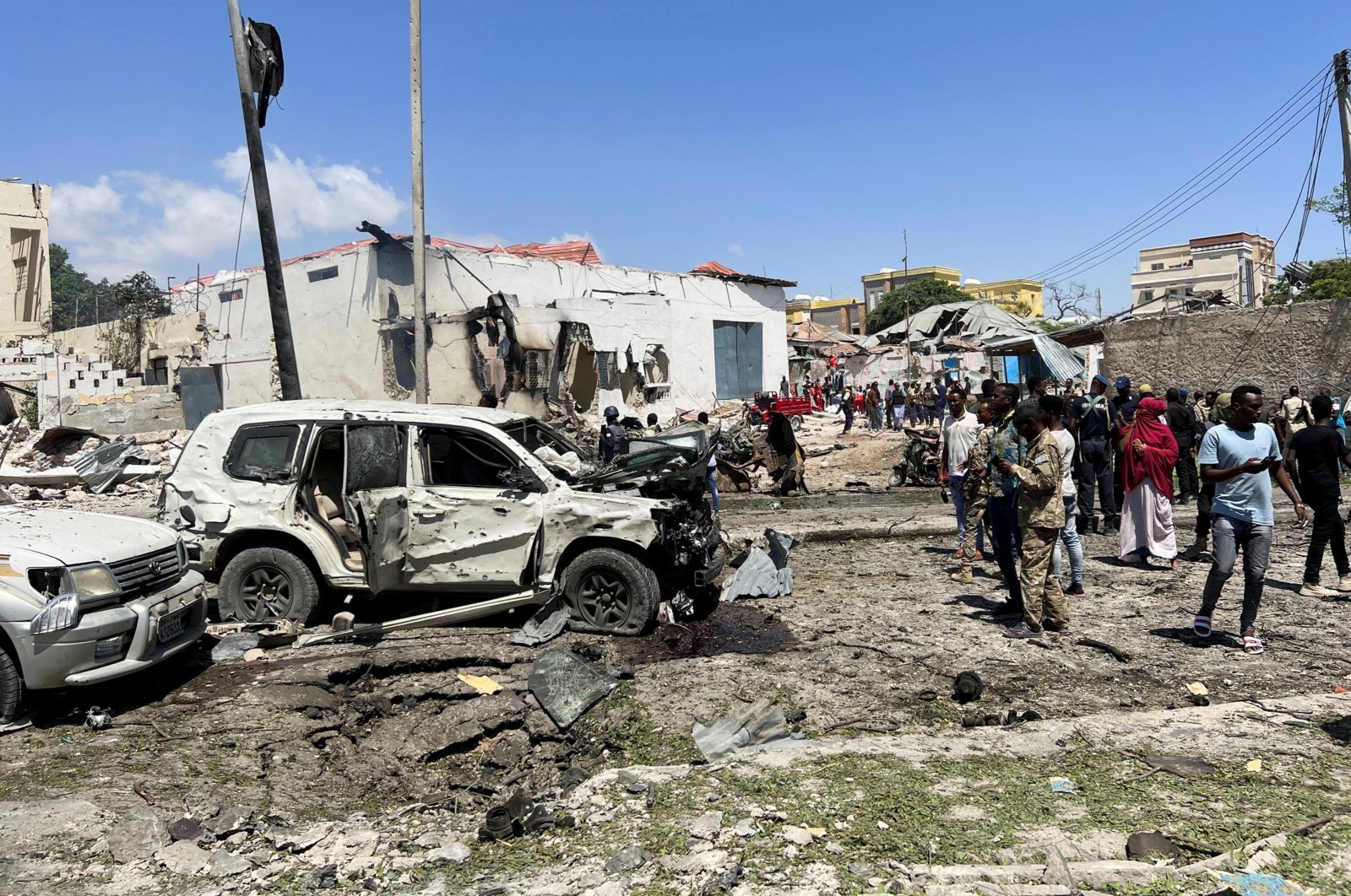 Civilians look at the wrecked vehicles at the scene of an explosion in the Hamarweyne district of Mogadishu, Somalia, Jan. 12, 2022. (Reuters Photo)