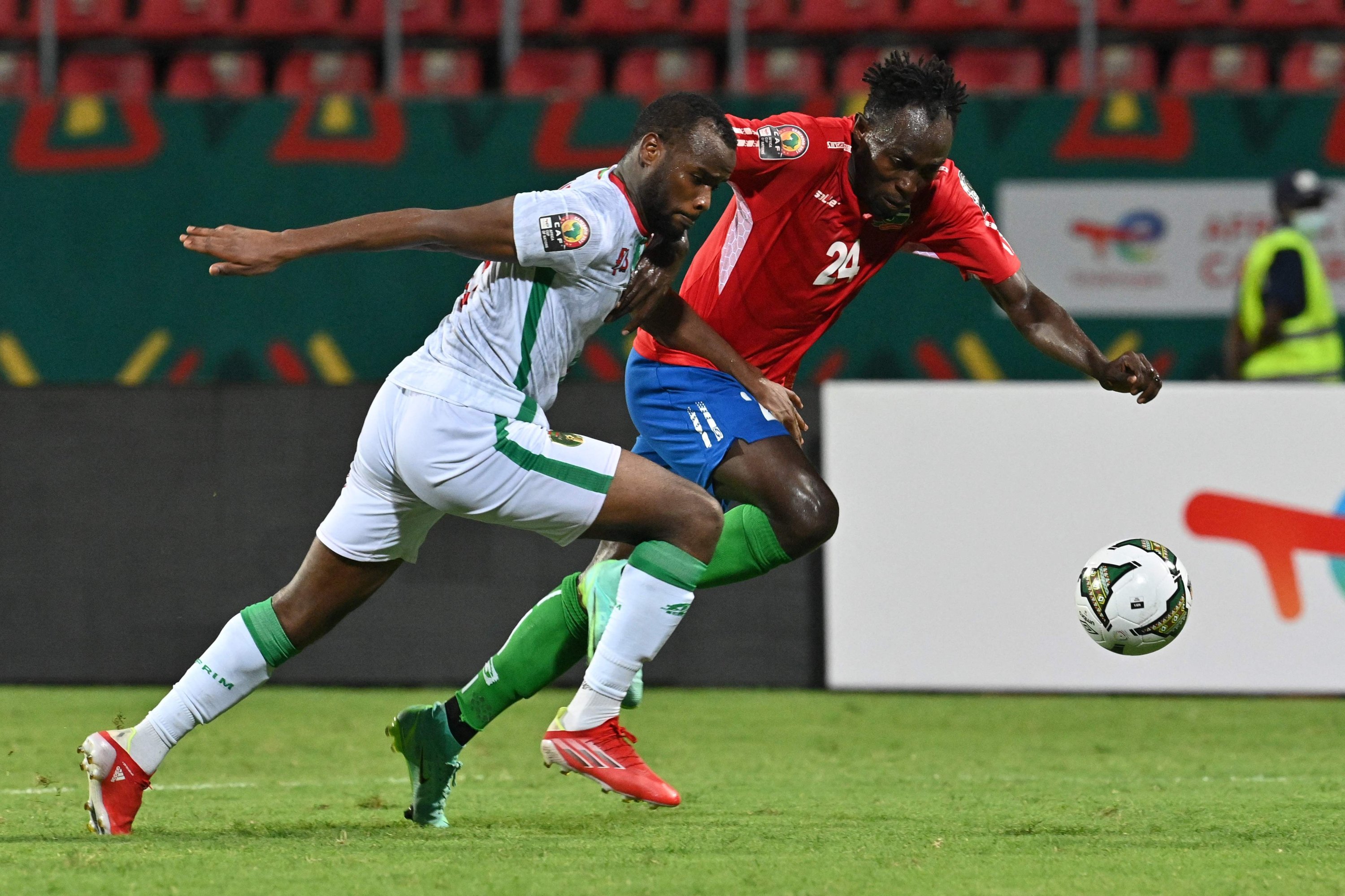 Dembo Darbou dari Gambia (kiri) ditantang saat pertandingan Piala Afrika melawan Mauritania, Limbe, Kamerun, 12 Januari 2022. (AFP Photo)