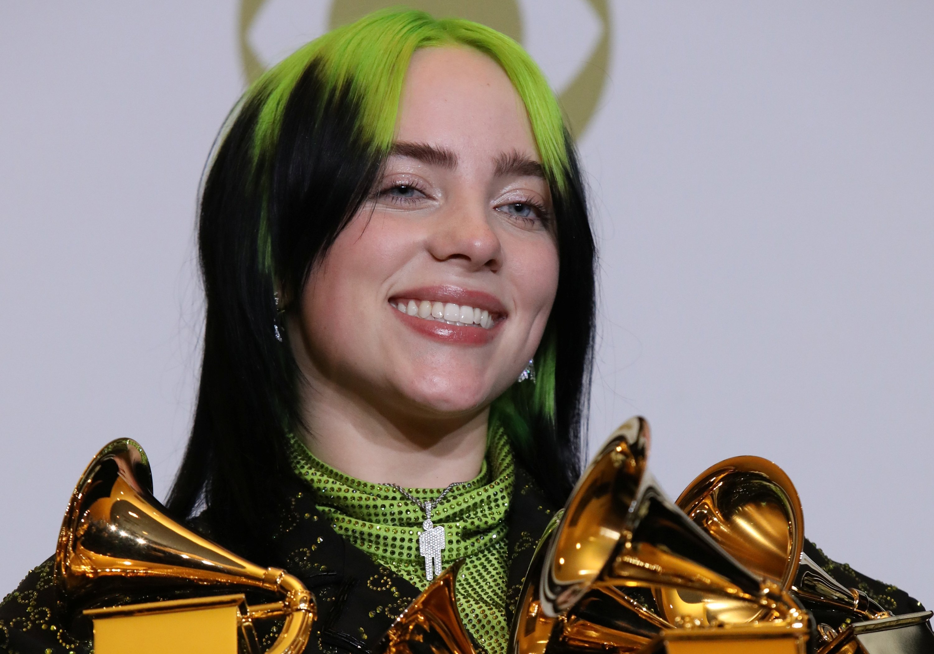 Billie Eilish poses backstage with her Grammy Awards, including Song of the Year for 