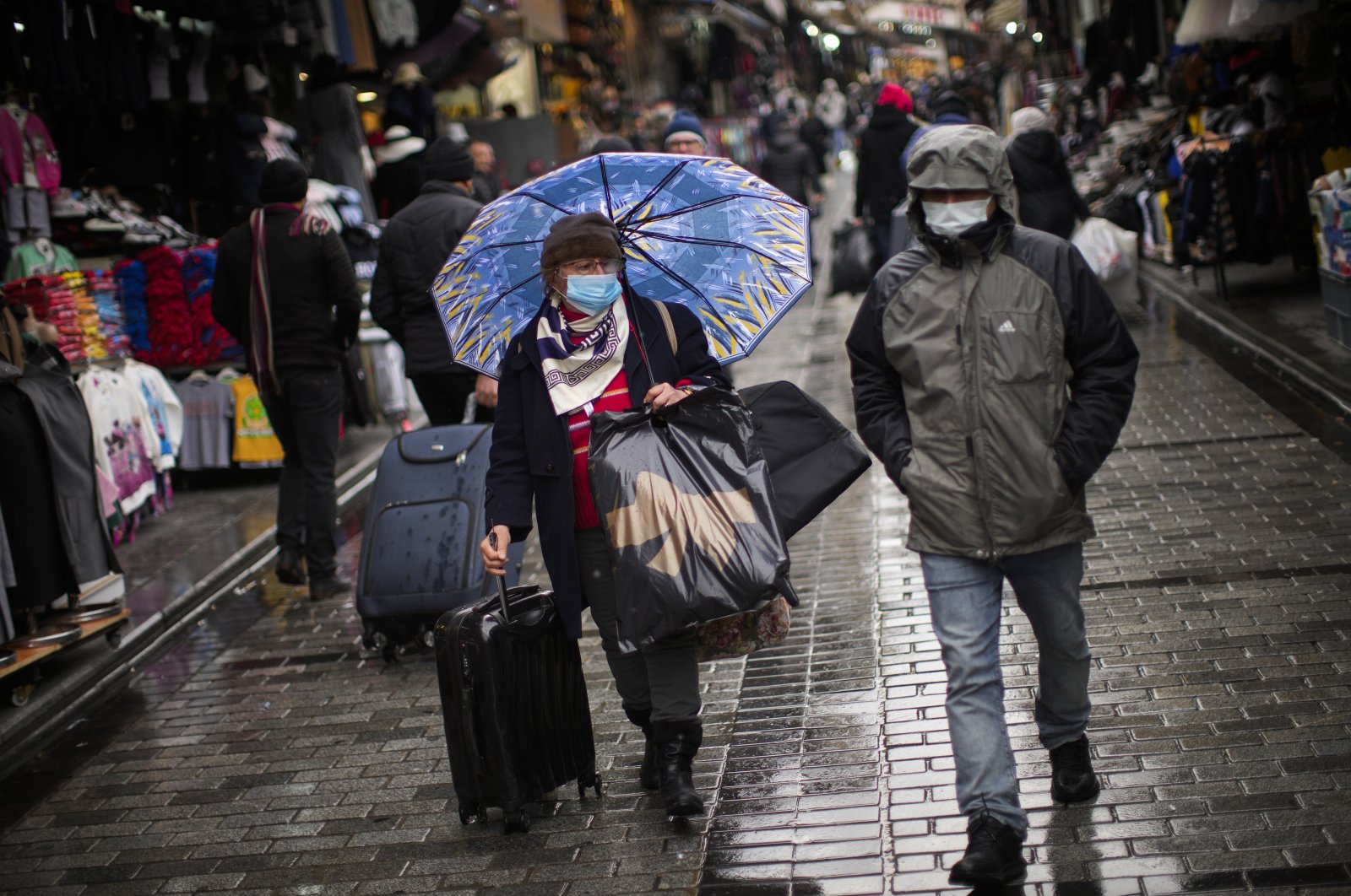 People wearing masks to prevent the spread of COVID-19, walk along a commercial area in Istanbul, Turkey, Jan. 12, 2022. (AP Photo)
