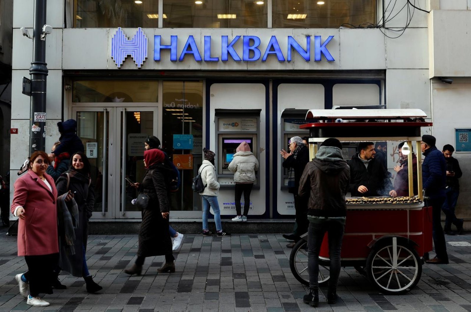 People walk past by a branch of Halkbank in central Istanbul, Turkey, Jan. 22, 2020. (Reuters Photo)