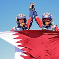 Nasser Al-Attiyah (R) and his co-driver Mathieu Baumel hold a Qatari flag as they celebrate the win, in Jeddah, Saudi Arabia, Jan. 14, 2022. (AFP PHOTO)