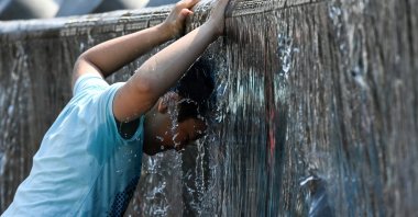 A boy cools off in a fountain during a hot summer day in downtown Moscow, Russia, July 13, 2021. (AFP Photo)