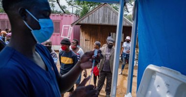 A health worker fills up a syringe with a vaccines dose against COVID-19 as people queue at the Kya Sands informal settlement to be vaccinated by the Witkoppen clinic in Johannesburg, South Africa, Dec. 8, 2021. (AFP Photo)