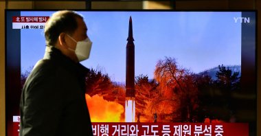 A man walks past a television report showing a news broadcast with file footage of a North Korean missile test, at a railway station in Seoul, South Korea, Jan. 14, 2022, after North Korea fired an unidentified projectile eastward in the country's third suspected weapons test in just over a week. (AFP Photo)