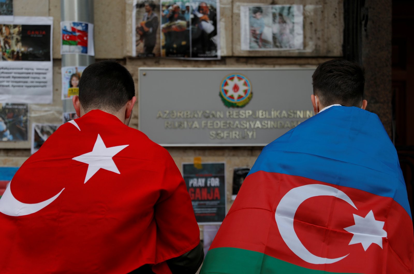 Men holding the national flags of Azerbaijan and Turkey stand next to a makeshift memorial for people killed in Azerbaijan during the military conflict over the region of Nagorno-Karabakh, outside the Azerbaijani Embassy in Moscow, Russia, Oct. 19, 2020. (REUTERS Photo)