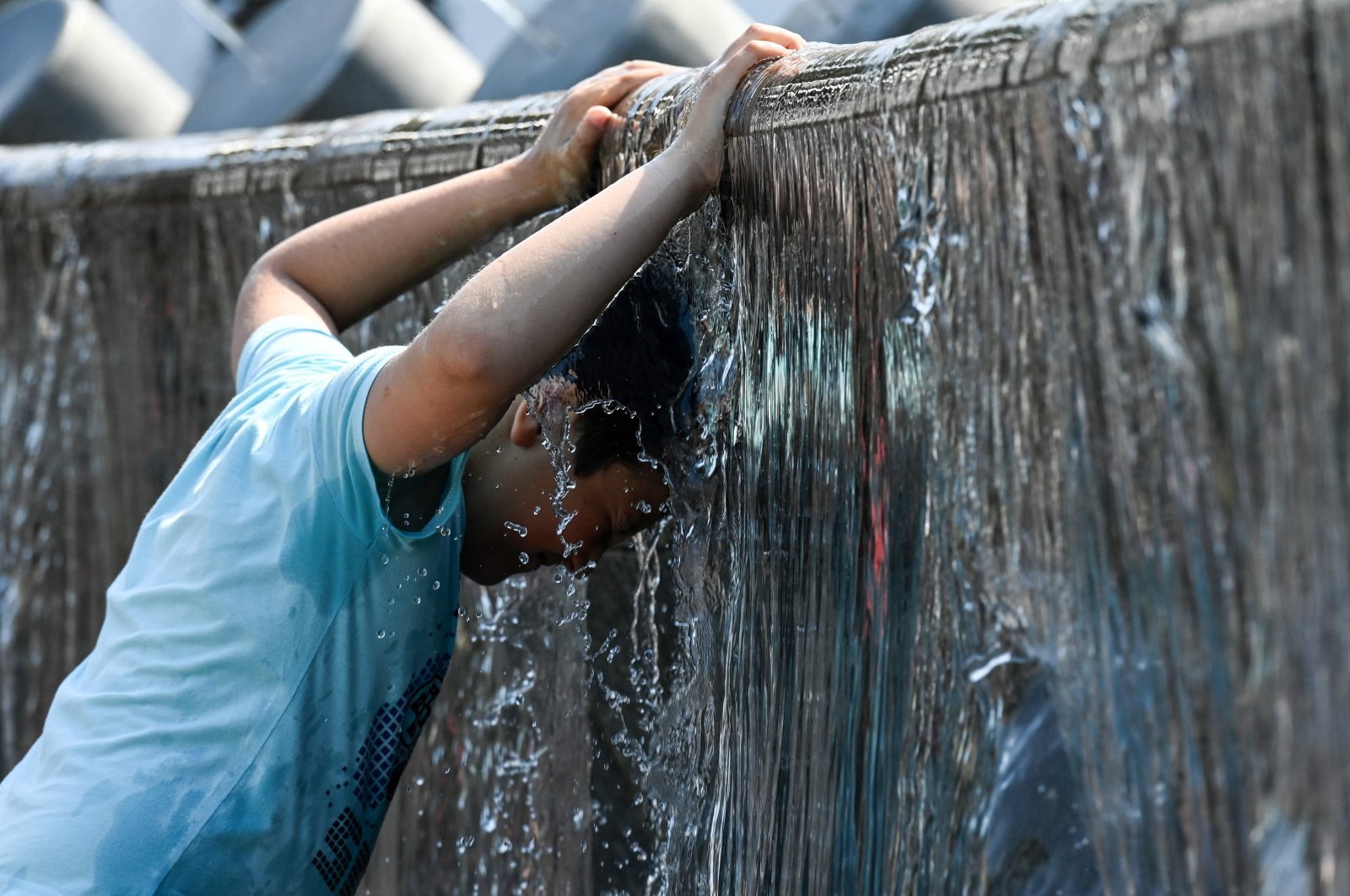 A boy cools off in a fountain during a hot summer day in downtown Moscow, Russia, July 13, 2021. (AFP Photo)