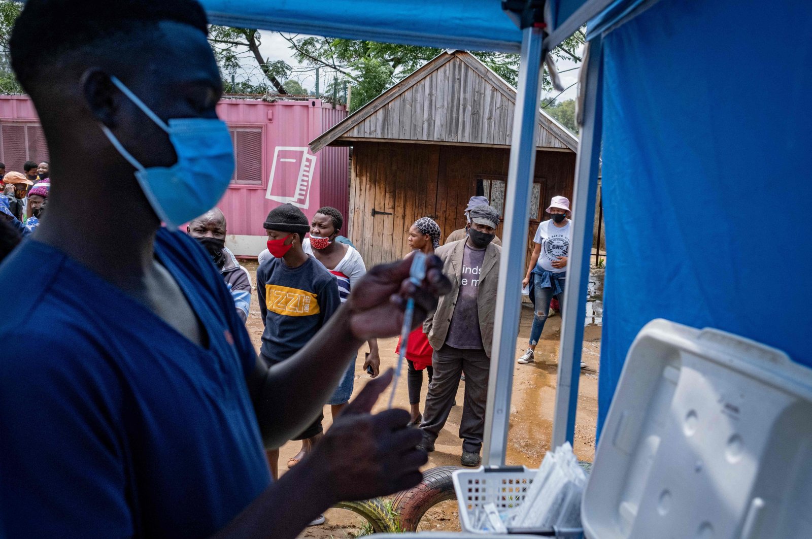A health worker fills up a syringe with a vaccines dose against COVID-19 as people queue at the Kya Sands informal settlement to be vaccinated by the Witkoppen clinic in Johannesburg, South Africa, Dec. 8, 2021. (AFP Photo)