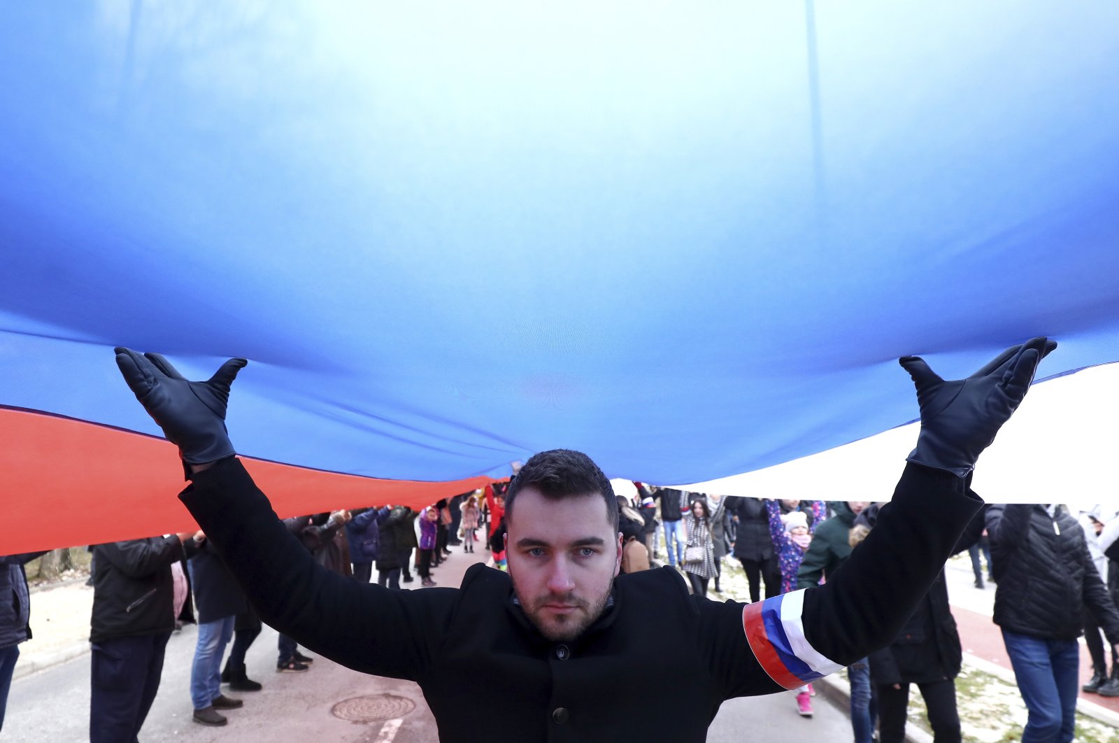 Bosnian Serbs march carrying a giant Serbian flag in Sarajevo, Bosnia, Sunday, Jan. 9, 2022. (AP Photo)