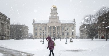 A person walks past the Old Capitol Building as snow falls during a winter storm warning, in Iowa City, Iowa, Jan. 14, 2022. (Joseph Cress/Iowa City Press-Citizen via AP)