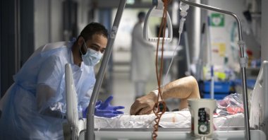 A medical staff member speaks with a COVID-19 patient in the infectious disease ward of the Strasbourg University Hospital, eastern France, Jan. 13, 2022. (AP Photo)