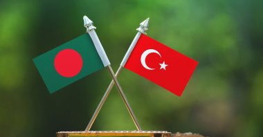 In this photo illustration, the flags of Bangladesh and Turkey are seen together with a blurred green background. (Photo by Shutterstock)