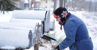 Samantha Ortiz-Beeson ventures out in a snowstorm to gather mail in Baldwin City, Kansas, U.S. Jan. 15, 2022. (Reuters Photo)