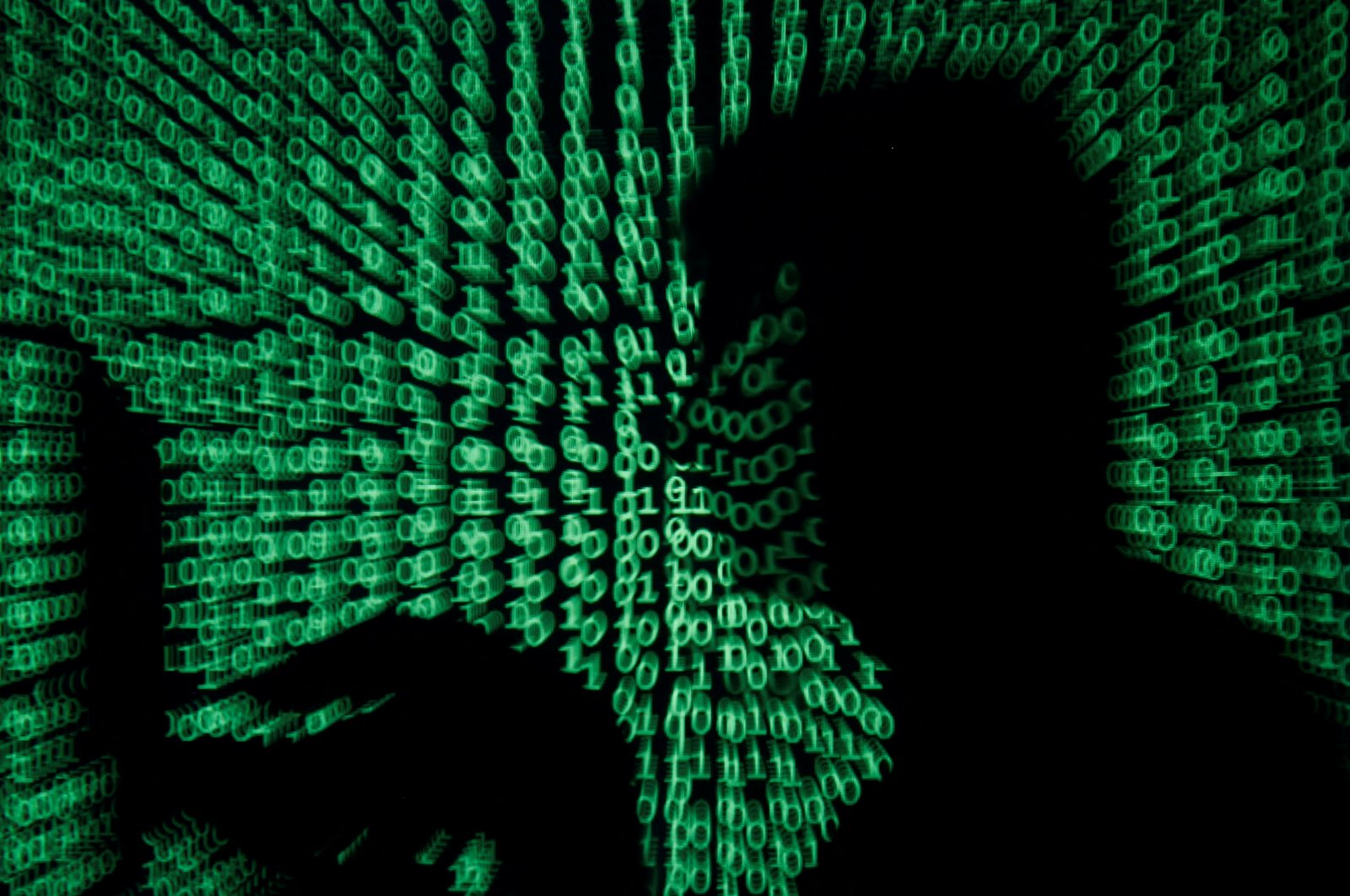 A man holds a laptop computer as cyber code is projected on him in this illustration picture taken on May 13, 2017. (Reuters Photo)