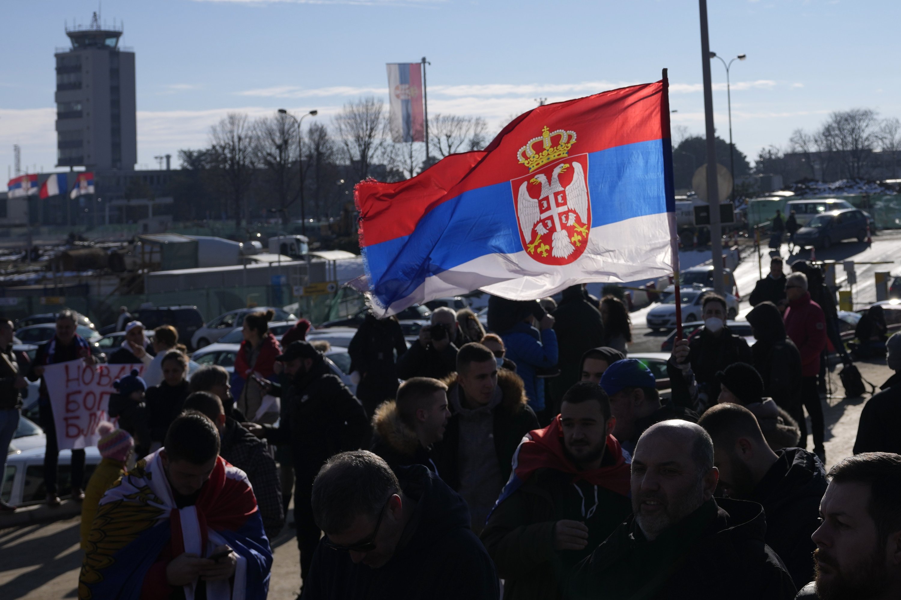 Fans mengibarkan bendera Serbia saat pemain tenis Serbia Novak Djokovic tiba di bandara Nikola Tesla di Beograd, Serbia, 17 Januari 2022. (AP Photo)