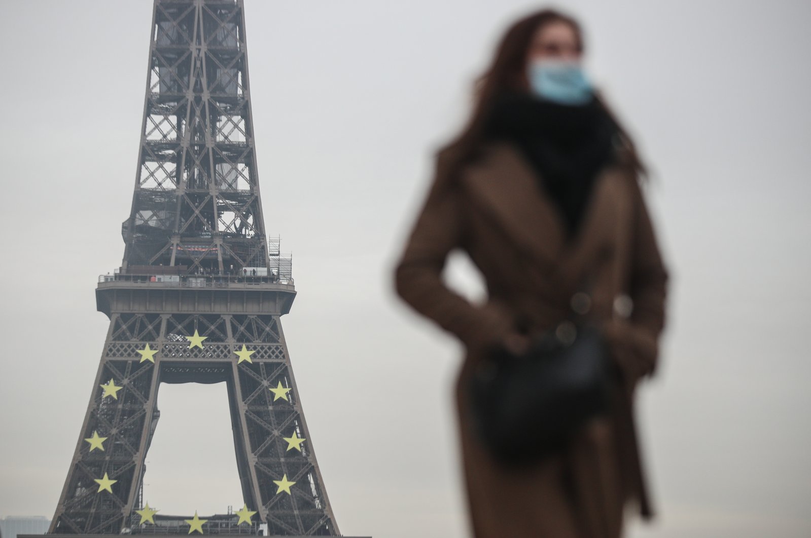 A woman wearing a face mask walks near the Eiffel Tower in Paris, France, Jan. 12, 2022. (EPA-EFE Photo)