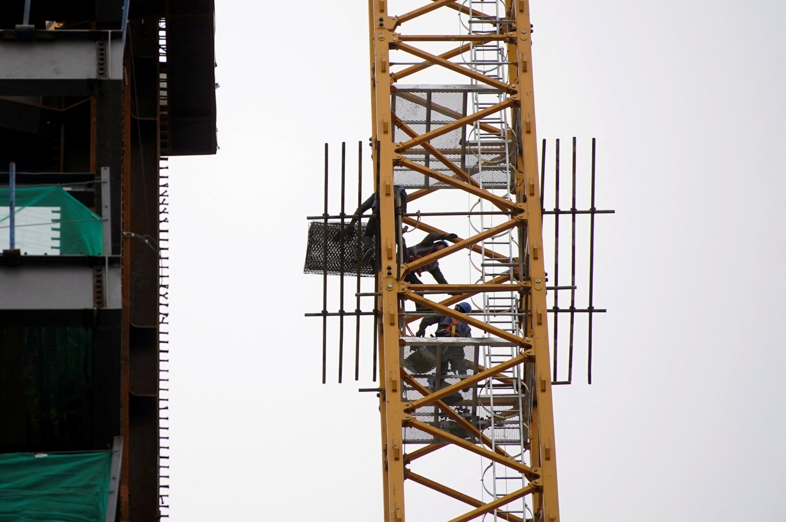 Workers labor while on a crane at a construction site in Shanghai, China, Jan. 14, 2022. (Reuters Photo)