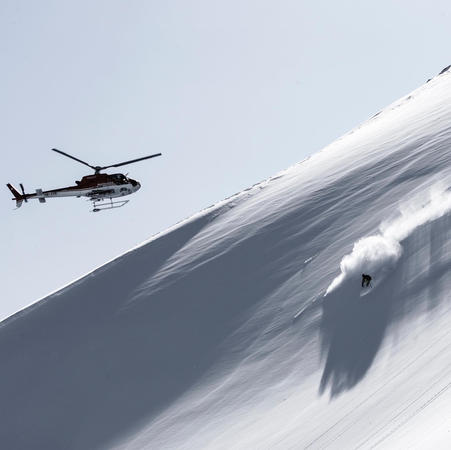 Seorang pemain ski menuruni bukit saat helikopter melacak kemajuan mereka di Pegunungan Kaçkar, Rize, Turki utara, 17 Januari 2022. (Foto DHA)