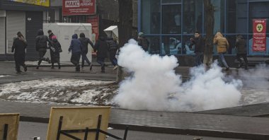 Kazakh protesters run during protest over a hike in energy prices in Almaty, Kazakhstan, Jan. 5, 2022 (EPA Photo)