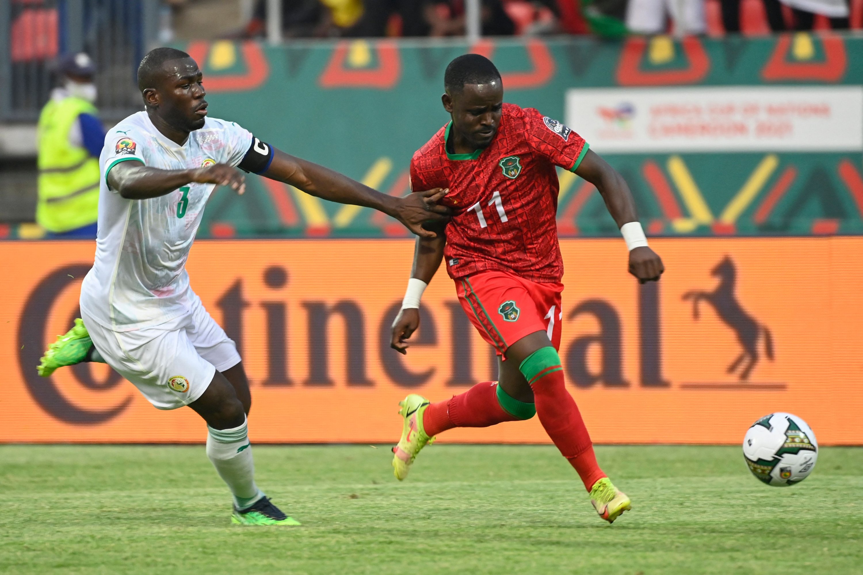 Bek Senegal Kalidou Koulibaly (kiri) berebut bola dengan penyerang Malawi Gabadinho Mhango (kanan) dalam pertandingan Piala Afrika 2021 melawan Malawi, Bafoussam, Kamerun, 18 Januari 2022. (AFP Photo)