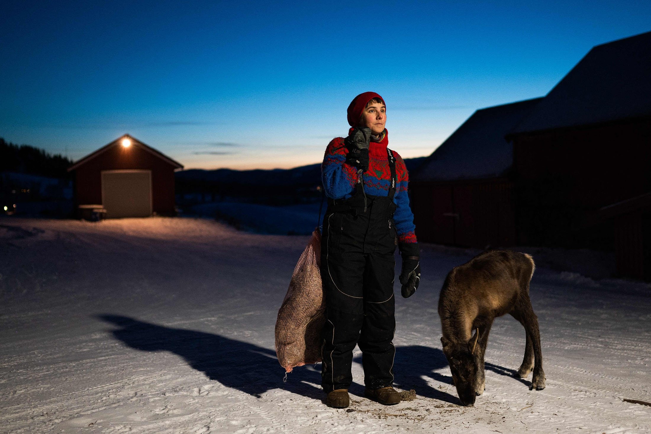Sissel Stormo Holtan pose à côté d'un renne devant sa maison à Namdalseid, dans le comté de Troendelag, en Norvège, le 7 décembre 2021. (Photo AFP)