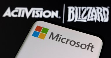 Microsoft logo is seen on a smartphone placed on displayed Activision Blizzard logo in this illustration taken on Jan. 18, 2022. (Reuters Photo)