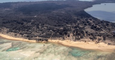 In this photo provided by the New Zealand Defense Force, volcanic ash covers roof tops and vegetation in an area of Tonga, Jan. 17, 2022. (AP Photo)