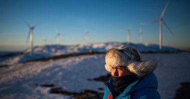 Reindeer herder John Kristian Jama looks out toward wind turbines of the Storheia wind farm, one of Europe's largest land-based wind parks, in Afjord municipality, Norway, Dec. 7, 2021. (AFP Photo)