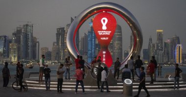 People gather around the official countdown clock showing for the FIFA 2022 World Cup, Doha, Qatar, Nov. 25, 2021. (AP Photo)