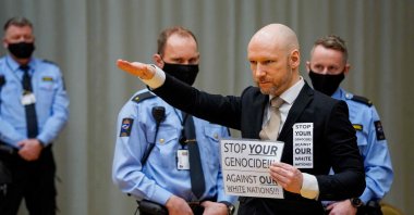 Anders Behring Breivik raises his arm to do the Nazi salute as he arrives on the first day of the trial where he is requesting release on parole, at a makeshift courtroom in Skien prison, Norway, Jan. 18, 2022. (AFP Photo)