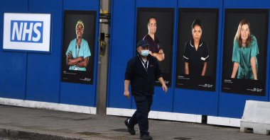 A man passes a temporary &quot;Nightingale&quot; field hospital constructed in a car park of St. Georges Hospital in south London, Britain, Jan. 3, 2022. (EPA Photo)