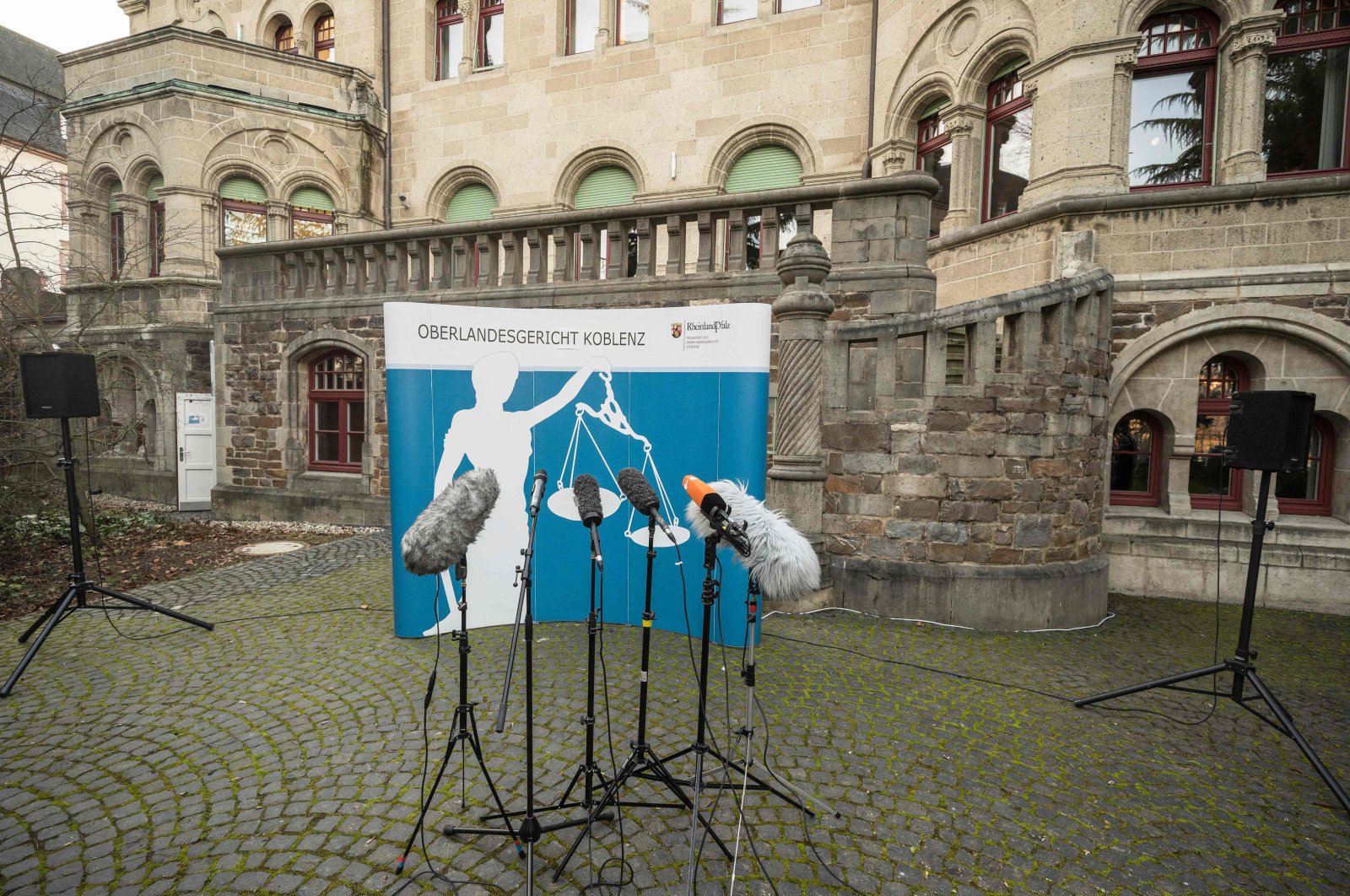 Microphones are set up in front of a banner featuring a &quot;Justitia&quot; ahead of a press conference outside the courthouse in Koblenz, western Germany, Jan. 13, 2022 (AFP Photo)