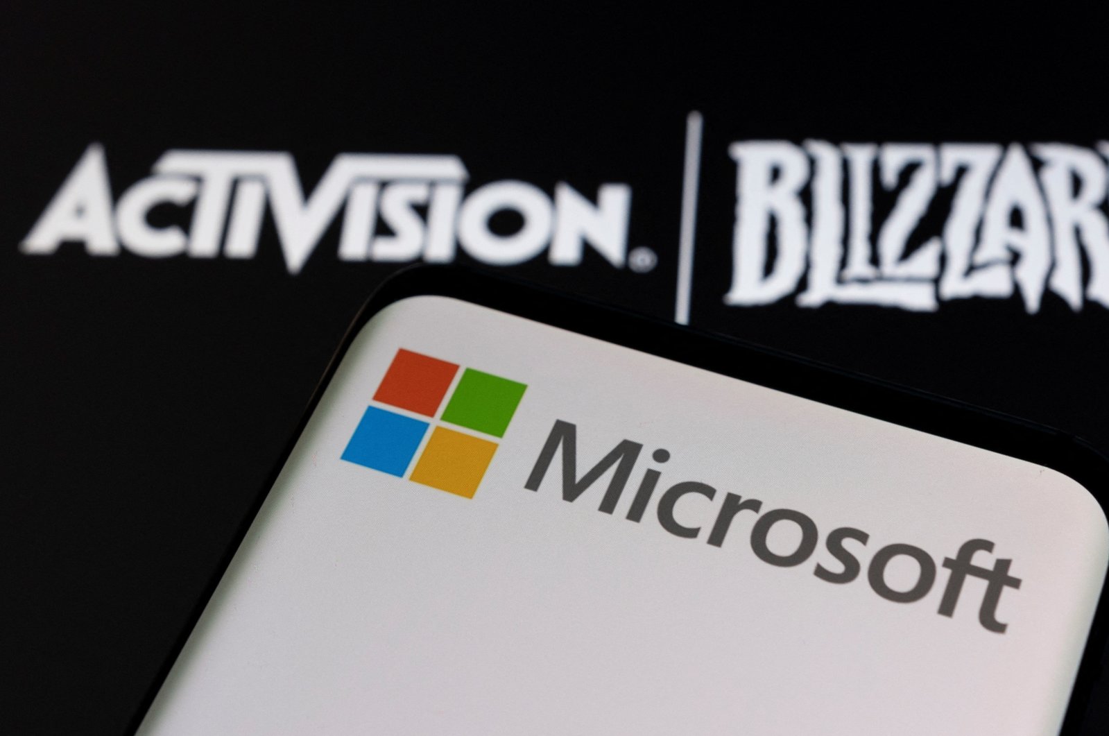 Microsoft logo is seen on a smartphone placed on displayed Activision Blizzard logo in this illustration taken on Jan. 18, 2022. (Reuters Photo)