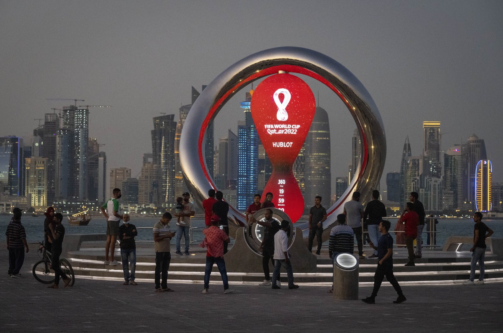 People gather around the official countdown clock showing for the FIFA 2022 World Cup, Doha, Qatar, Nov. 25, 2021. (AP Photo)