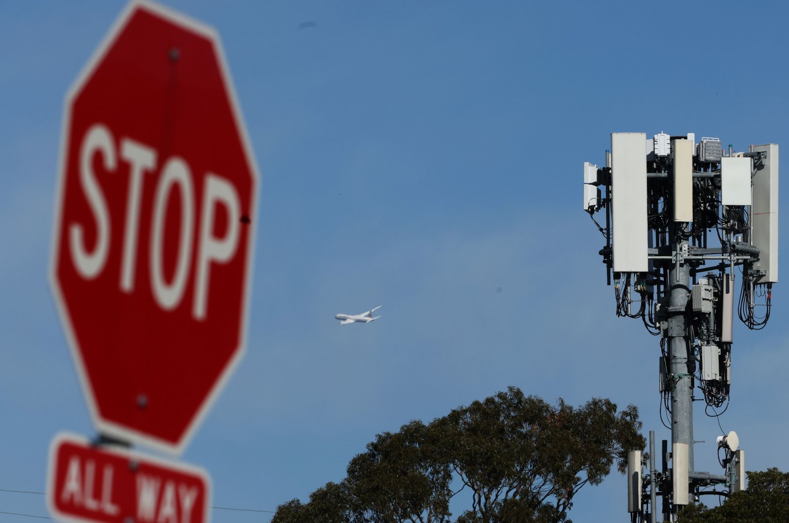 A plane flies by a cellular tower as it takes off from San Francisco International Airport in San Bruno, California, U.S., Jan. 18, 2022. (AFP Photo)