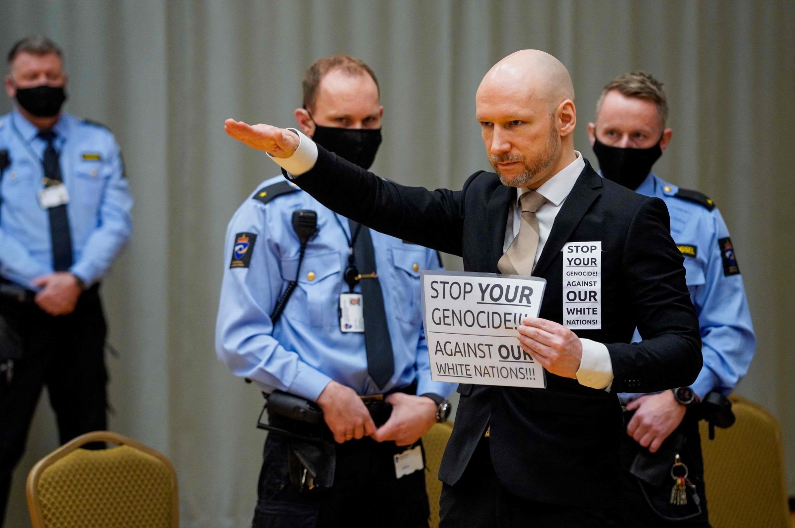Anders Behring Breivik raises his arm to do the Nazi salute as he arrives on the first day of the trial where he is requesting release on parole, at a makeshift courtroom in Skien prison, Norway, Jan. 18, 2022. (AFP Photo)