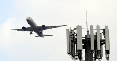 A cellular tower stands as a United Airlines Boeing 787 Dreamliner airplane lands at Los Angeles International Airport (LAX) in the Lennox neighborhood of Los Angeles, California, U.S., Jan. 19, 2022. (AFP Photo)