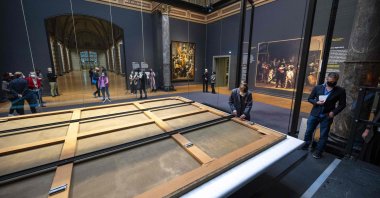 Restorers install a new aluminum canvas stretcher on Rembrandt's masterpiece "The Night Watch" at the start of a second phase of the painting's restoration at the Rijksmuseum in Amsterdam, Netherlands, Jan. 19, 2022. (AFP)