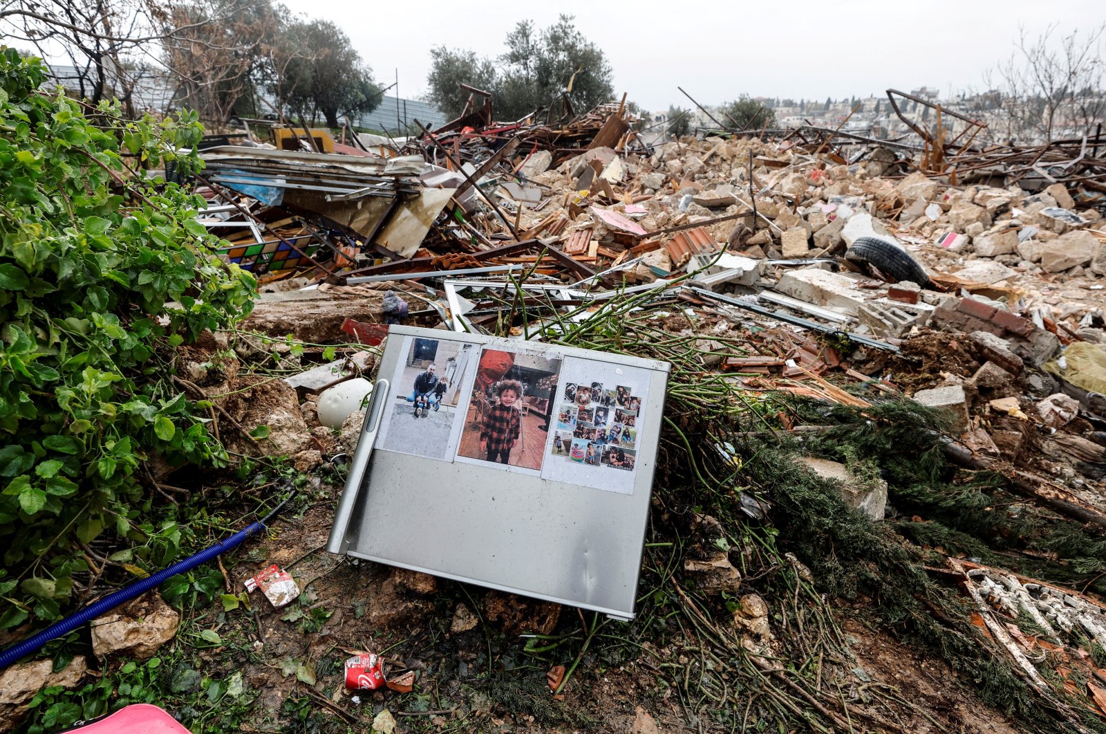Family photos are seen on the remains of a refrigerator at the site of a demolished house in the Sheikh Jarrah neighborhood of East Jerusalem, occupied Palestine, Jan. 19, 2022. (Reuters Photo)