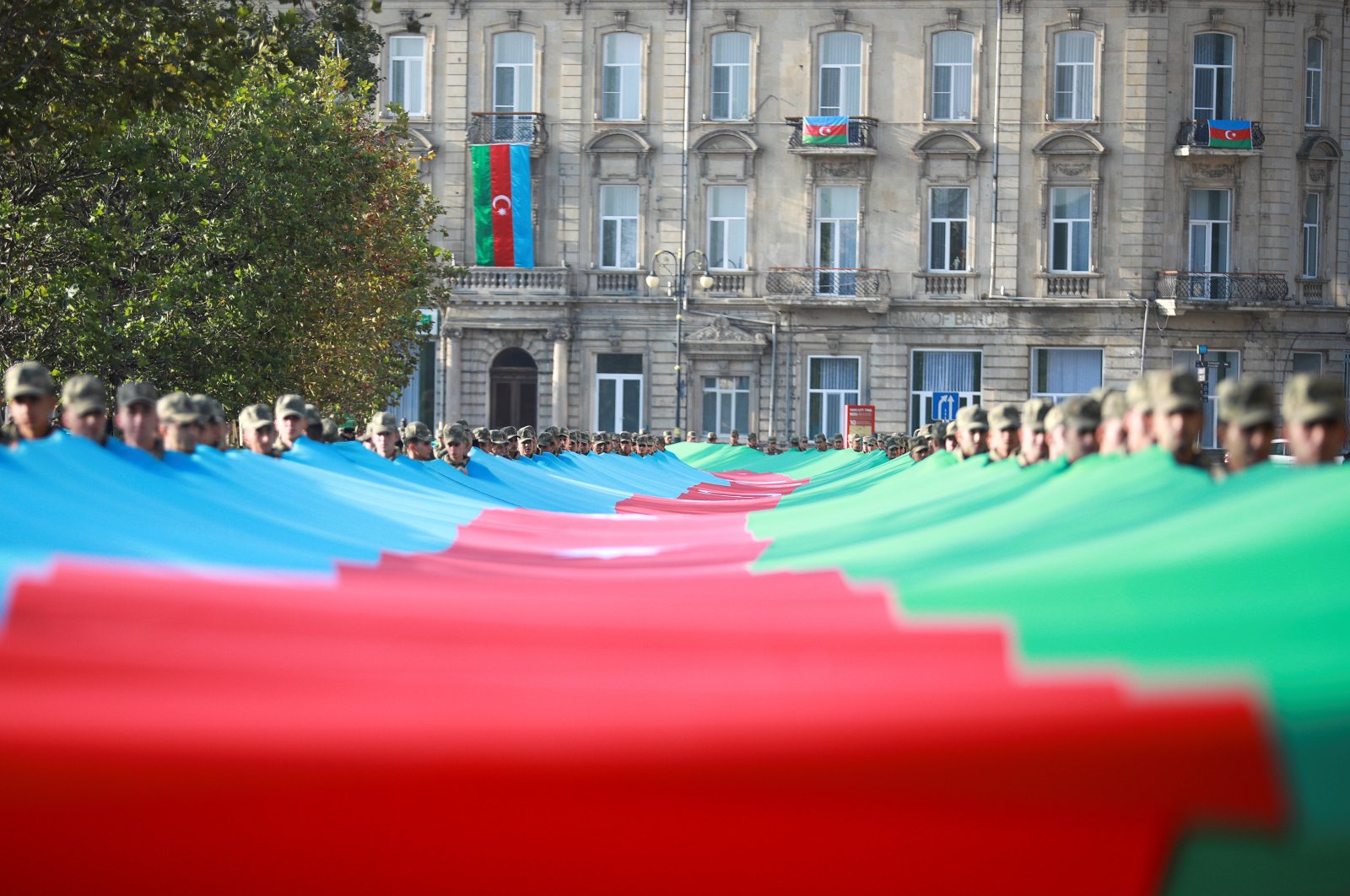 Azerbaijani service members carry a giant flag during a procession marking the anniversary of the end of the 2020 military conflict over Nagorno-Karabakh from Armenian occupation, Nov. 8, 2021. (Reuters File Photo)