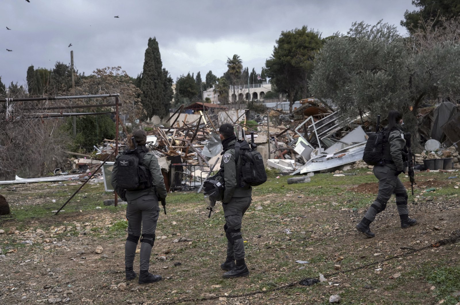 Israeli border police officers stand next to the ruins of a Palestinian house demolished by the Jerusalem municipality, in the flashpoint East Jerusalem neighborhood of Sheikh Jarrah, occupied Palestine, Jan. 19, 2022. (AP Photo)