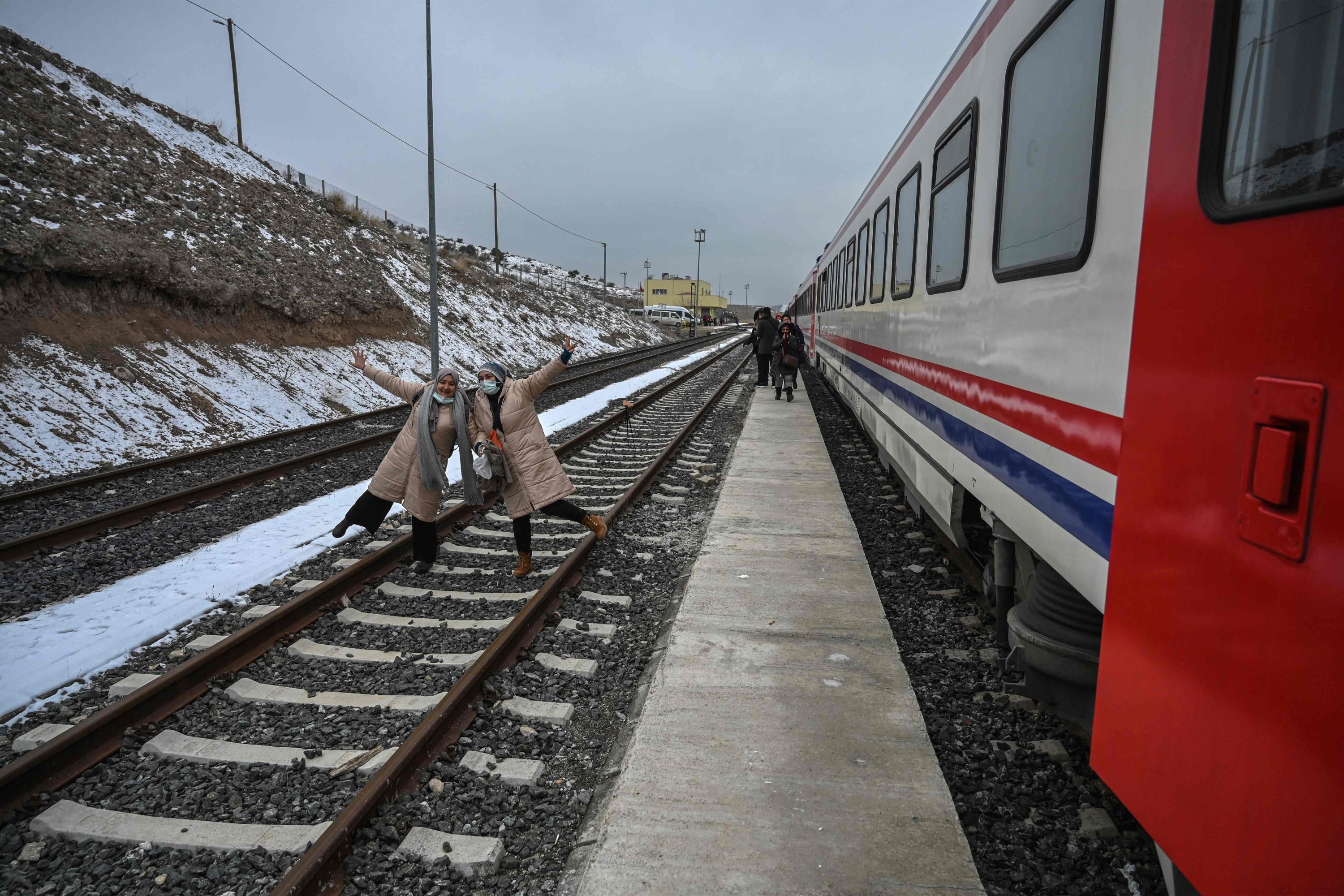 Penumpang kereta Eastern Express berpose saat berhenti di stasiun kereta Ili, Turki, 6 Januari 2022. (AFP Photo)
