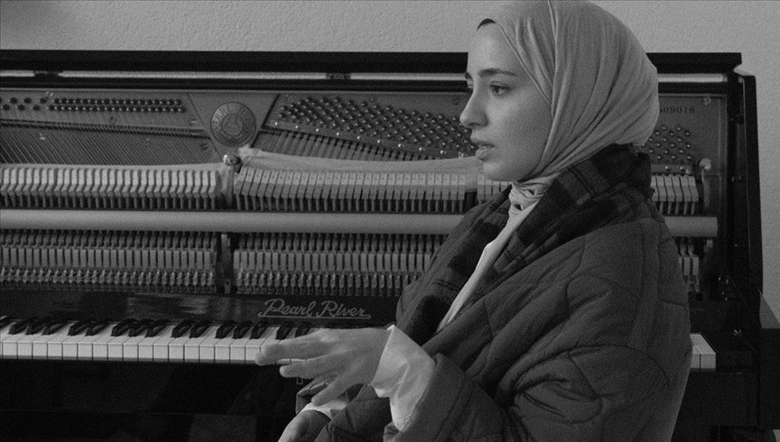 Büşra Kayıkçı talks in front of a piano. (AA)